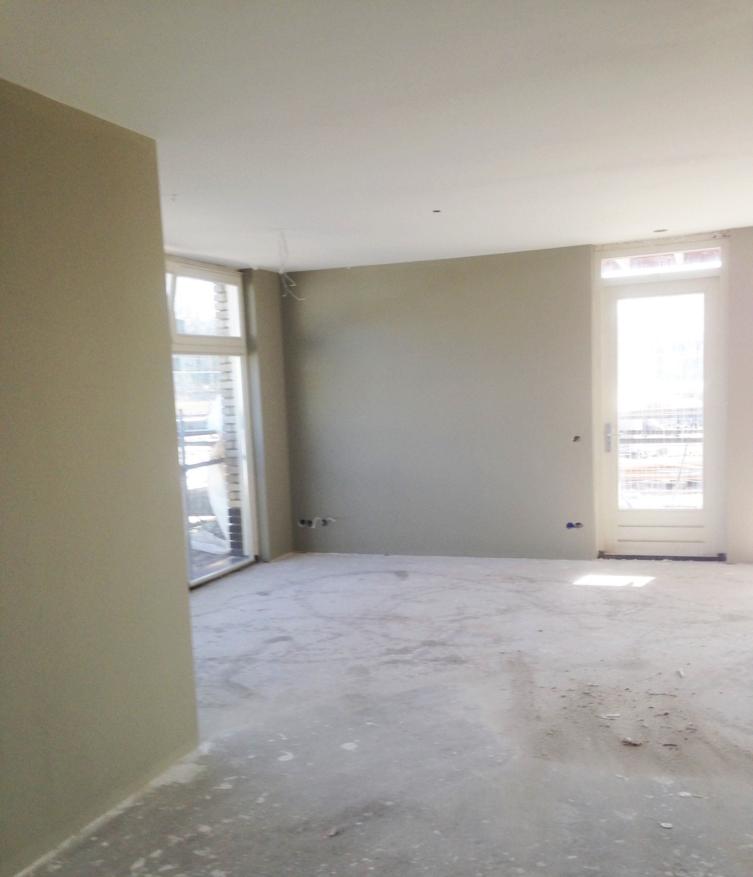 Interieur in sage muurverf met wit plafond en kozijnen.